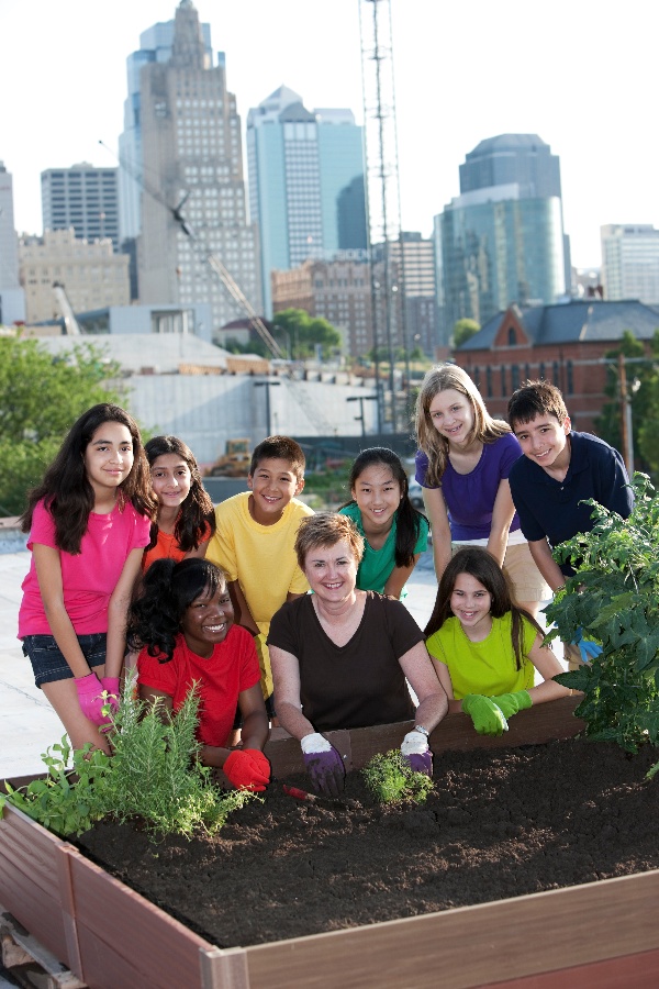 Children and an adult at a rooftop urban garden