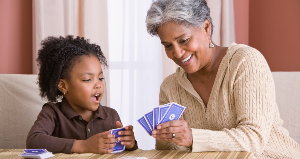 Grandma and granddaughter play cards