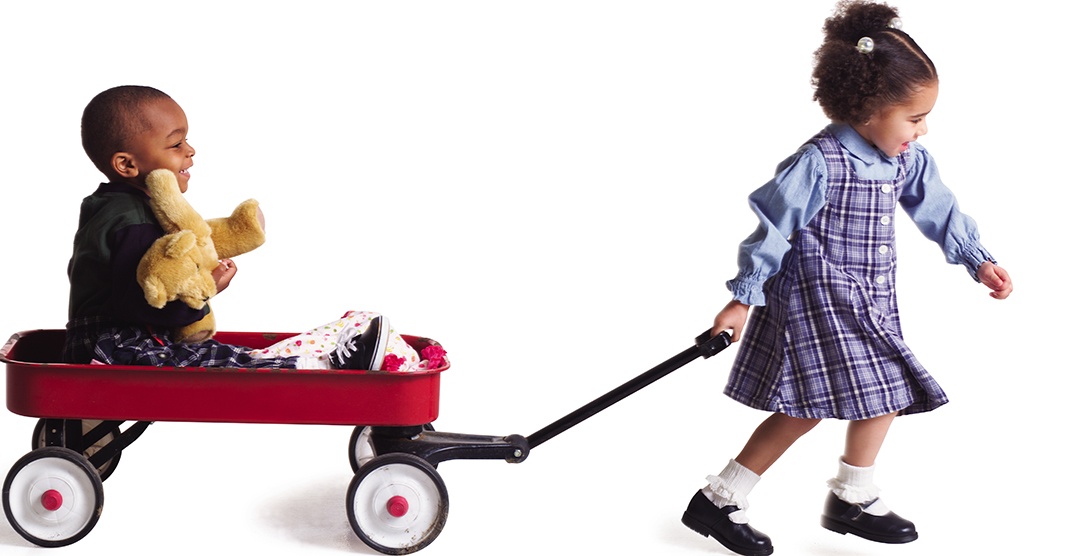 Girl pulling boy in wagon
