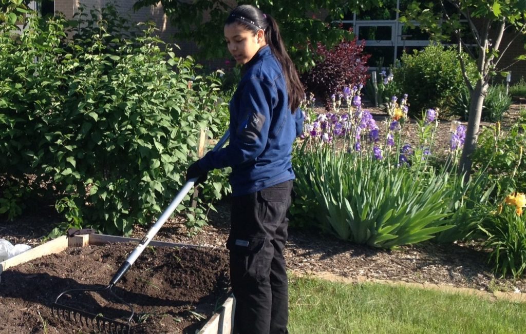 A student waters the garden at Pike High School