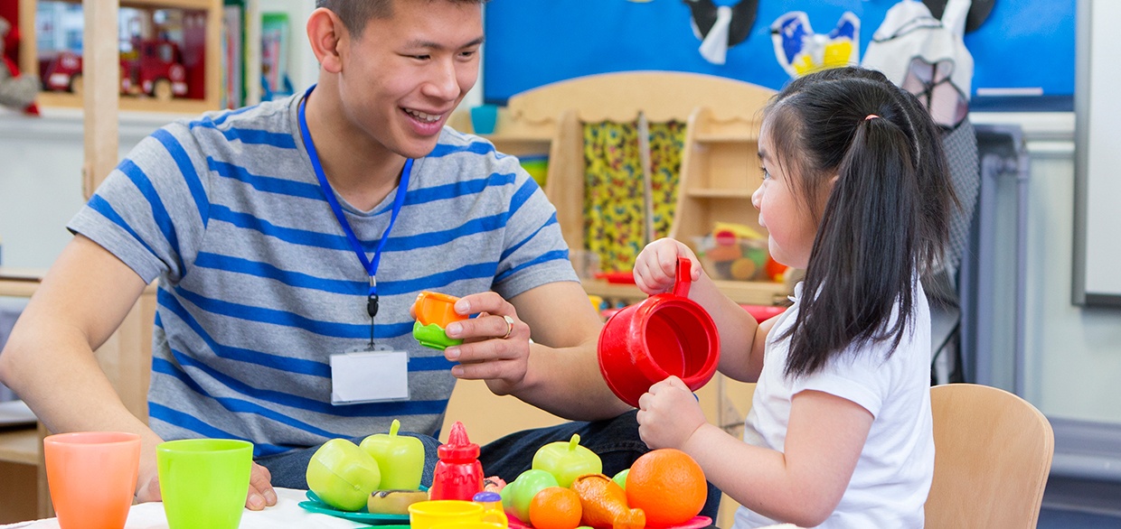 Teacher and student play with pretend food