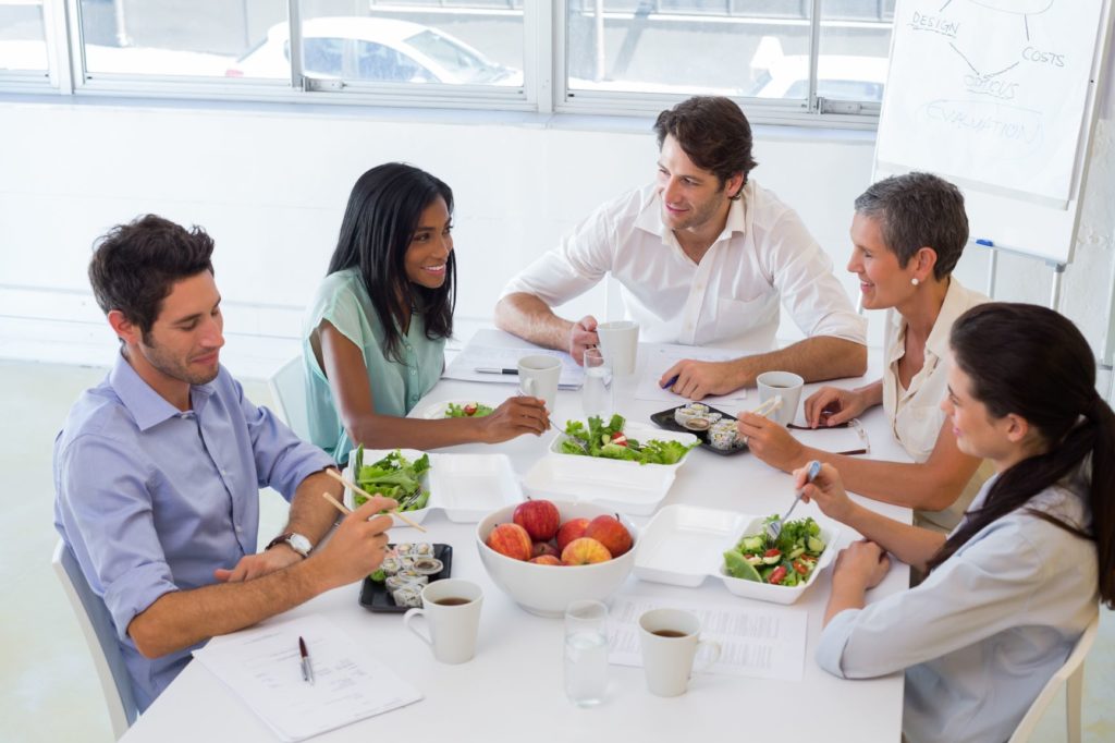 Coworkers sharing healthy lunches at a table