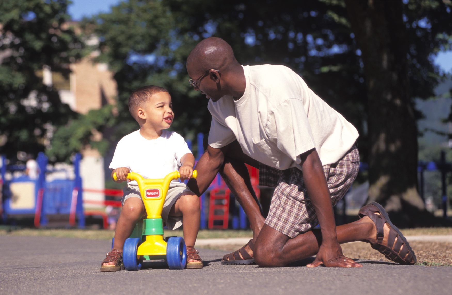 Dad and son on tricycle outside