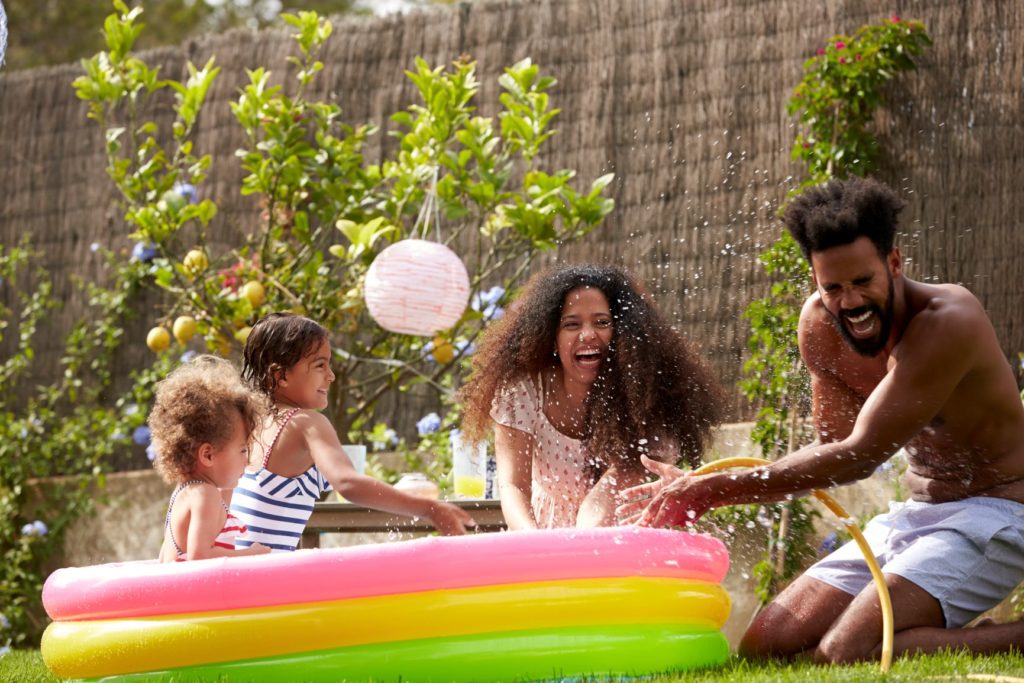 Family plays outside in child's pool