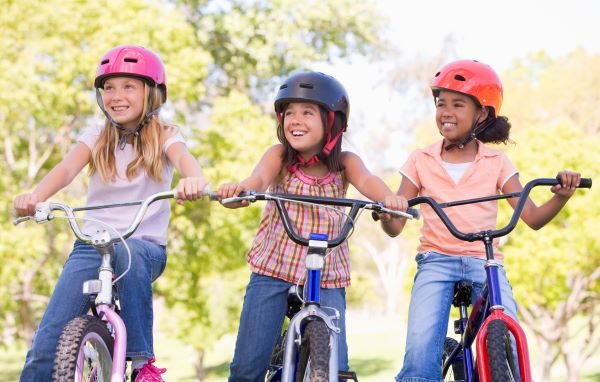 Three girls on bikes in the park
