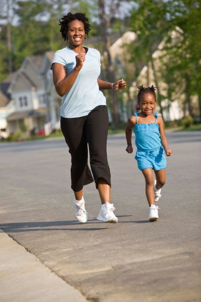 A mom and daughter take a jog outside in their neighborhood.