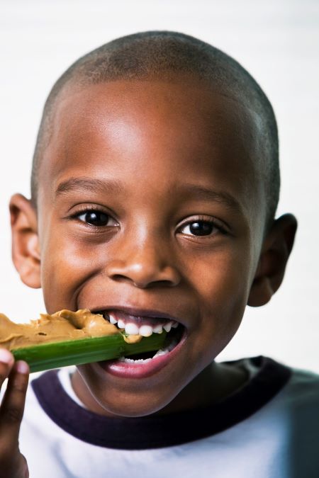 Boy eats celery and peanut butter