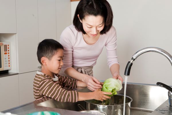 Mother and son wash lettuce