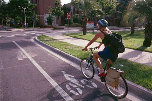 Woman riding bicycle in bike lane